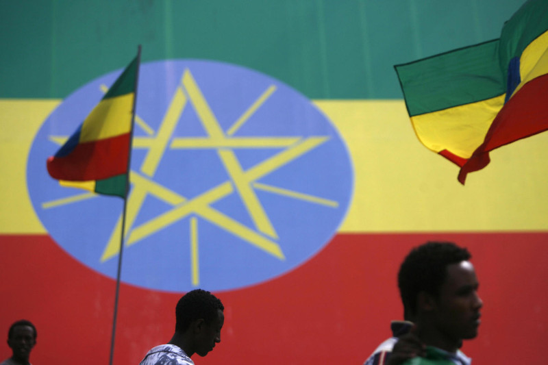 People walk in front of Ethiopian flags